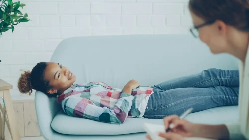 Girl lying on couch during therapy session with counselor